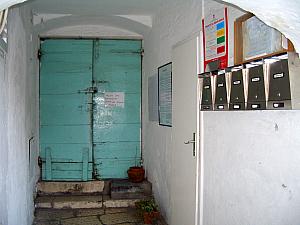 The door leads you out onto the street, and the mailboxes for the building's residents are along the right. 