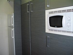 Opposite side of the kitchen, with the refrigerator/freezer, lots of cabinet space, and our microwave.