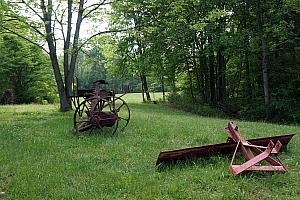 Old farming equipment in the fields, near the old buick from earlier.