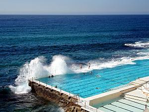 Some people are taking advantage of the rough surf, standing on the outer edge of the cleverly-placed seawater lap pool.