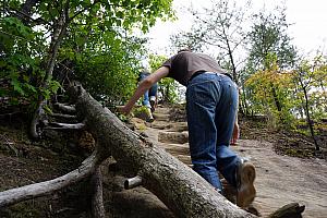 Adam climbing a rock staircase to the top of Double Arch