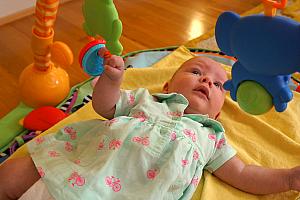 Playing with her favorite toy - the piano gym. This is the first time she ever grabbed the rings!