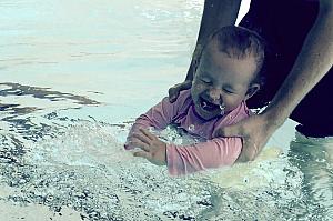 Getting splashed in the pool.