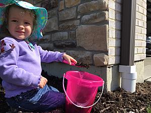 Capri helping dad pull weeds in the mulch beds